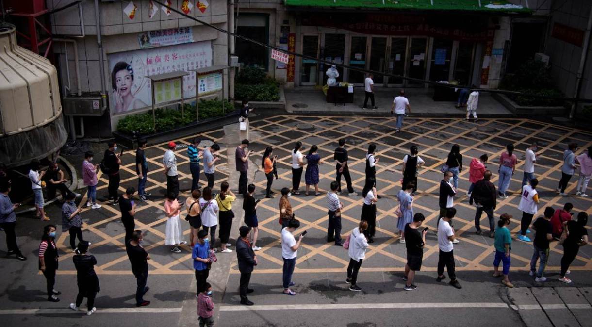 Moradores fazem fila para serem testados em Wuhan, na China