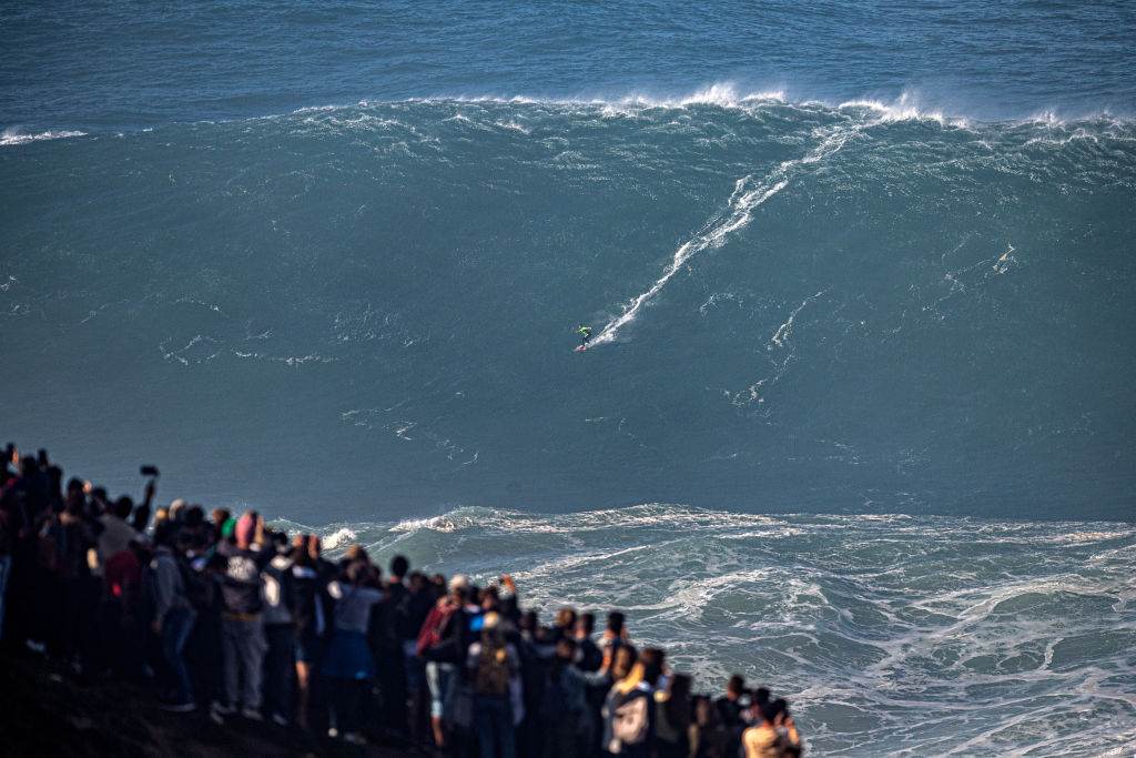 Carlos Burle pequenino enquanto surfa uma onda com mais de 20 metros em Portugal