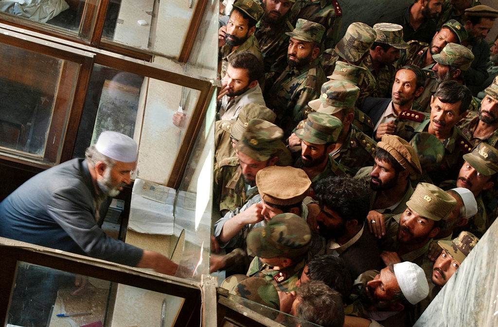 Foto de arquivo: soldados afegãos se aglomeram para trocar notas antigas por novas no Banco Central do país, em 9 de outubro de 2002, em Cabul, Afeganistão