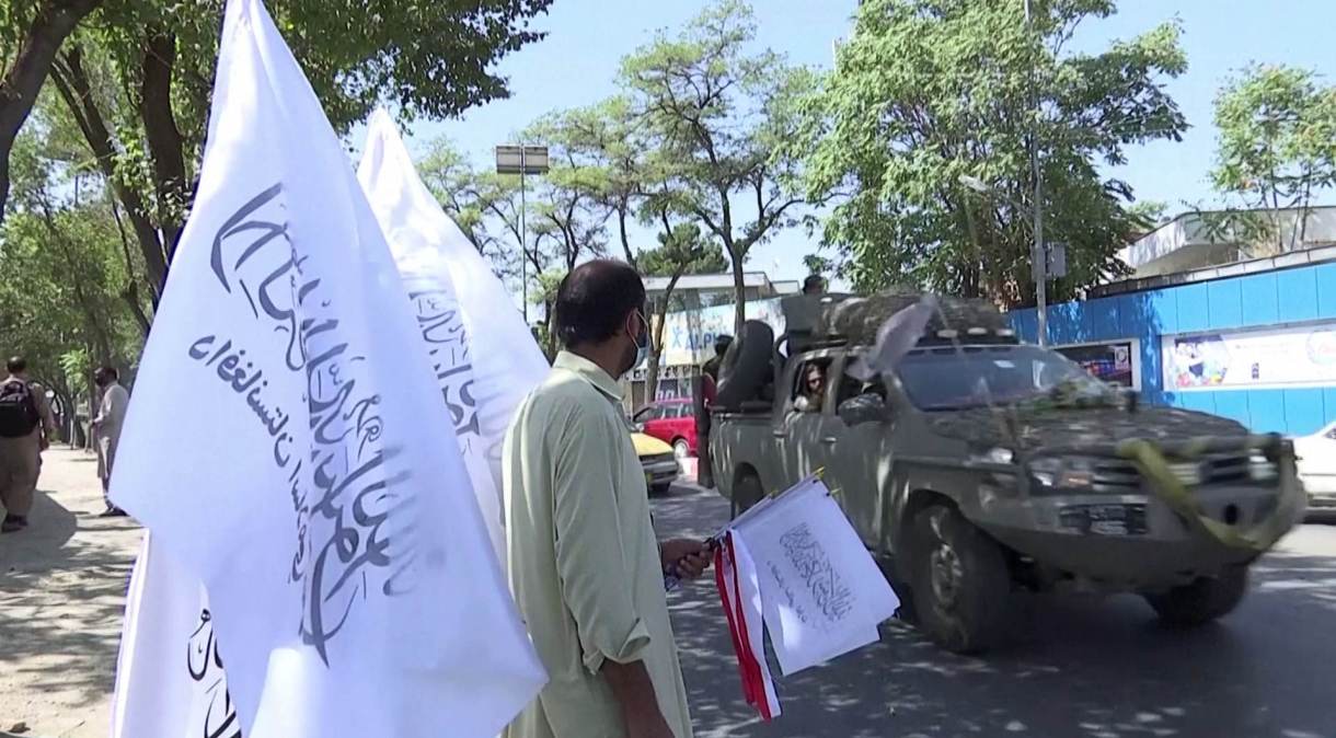 Homem vende bandeiras do Talibã em Cabul, Afeganistão
