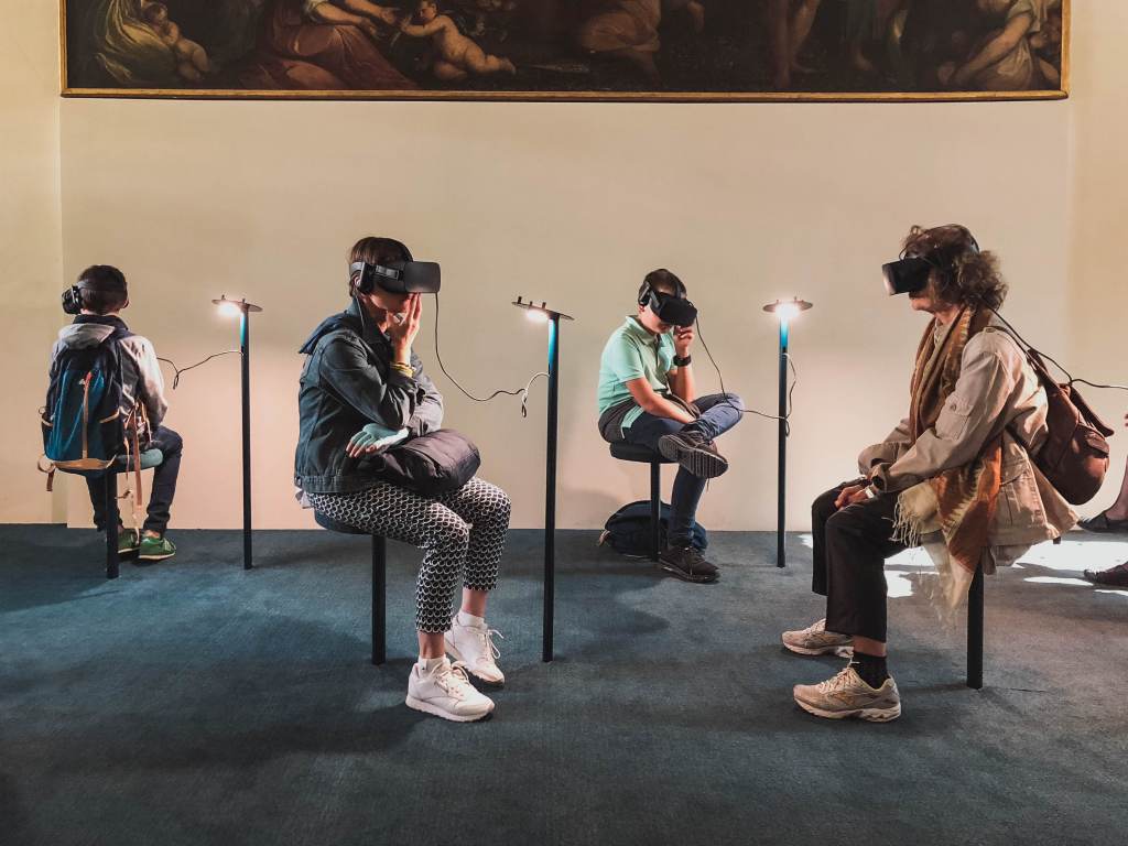 Quatro pessoas sentadas usando óculos de realidade virtual