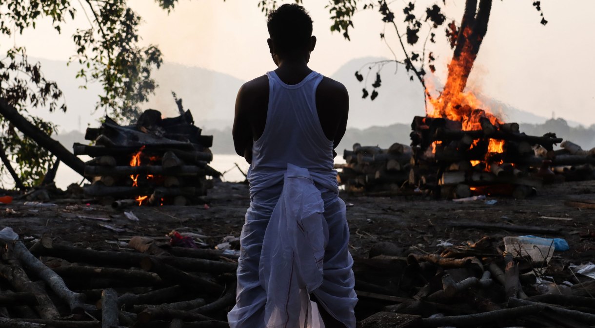 Familiar acompanha cremação de vítima da Covid-19 nas margens do rio Brahmaputra, em Guwahati