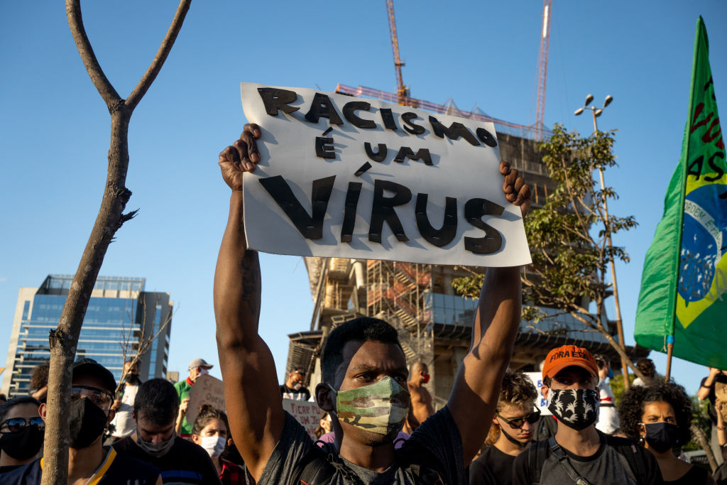 Manifestante levanta cartaz com os dizeres "racismo é um vírus" em protesto em São Paulo em junho de 2020