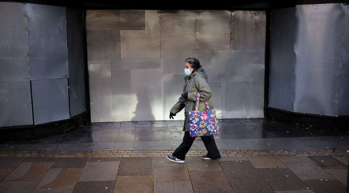 Mulher com máscara de proteção caminha em Preston, no Reino Unido