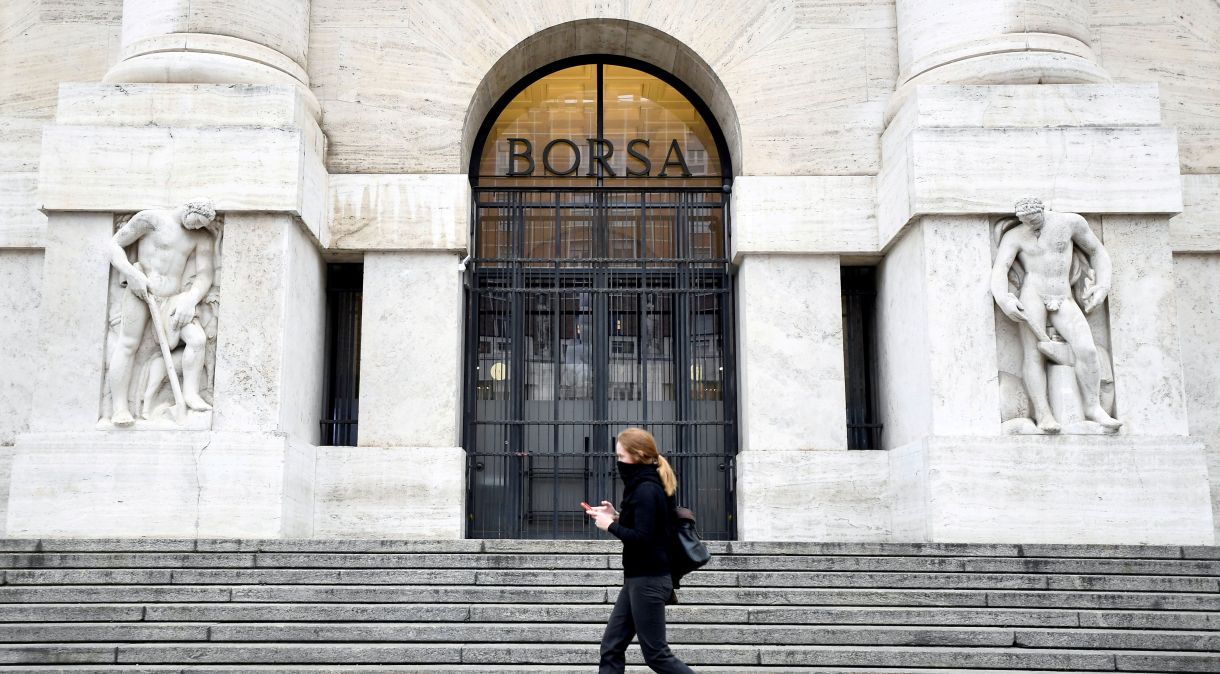 Pedestre caminha em frente à Bolsa de Valores de Milão