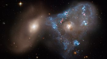 Duas galáxias disputam uma espéice de cabo de guerra, que ajudou a compor triângular em imagem