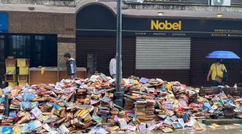Com enchentes, principal livraria da cidade perde centenas de livros. Exemplares descartados formaram montanha na calçada da loja, chamando a atenção de moradores