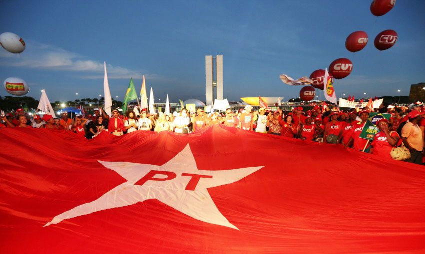 Manifestantes carregam bandeira do PT durante ato em Brasília