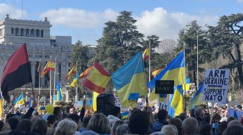 Dezenas de bandeiras ucranianas são vistas no protesto, além de cartazes contra o presidente Vladimir Putin