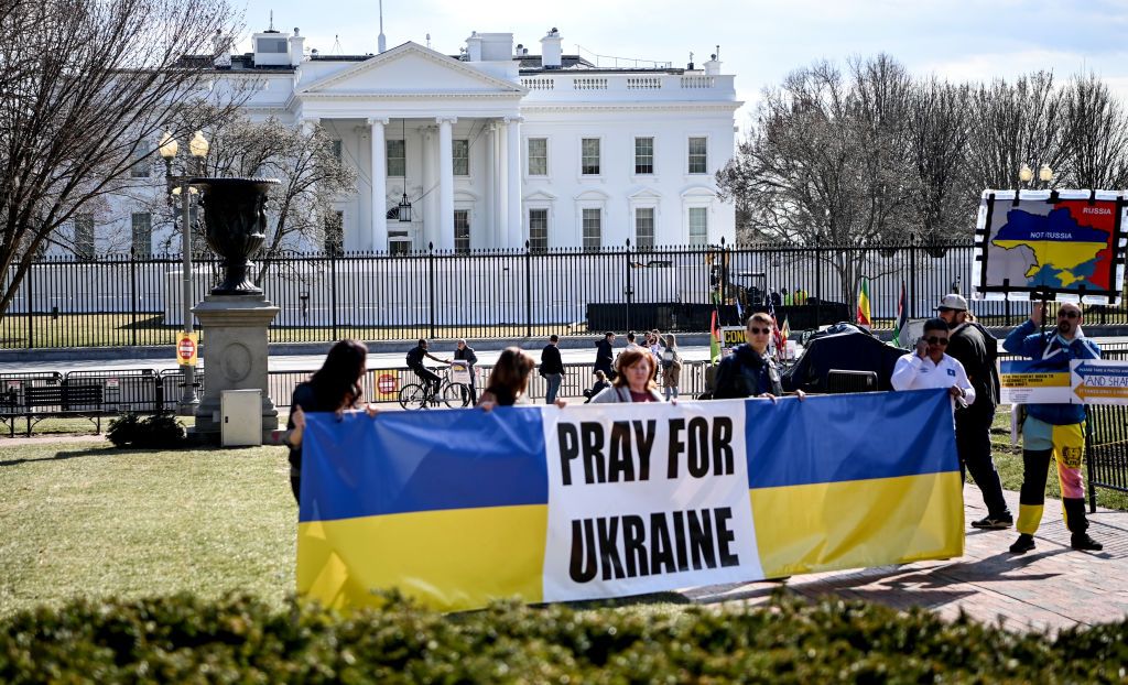 Manifestantes mostram placas dizendo "Reze pela Ucrânia" em frente à Casa Branca, sede do governo dos Estados Unidos, em Washington D.C.