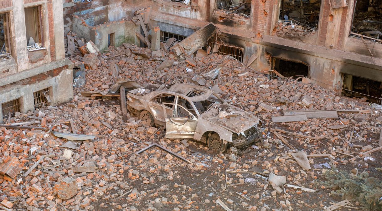 Carro destruído em meio aos escombros de uma universidade atingida por ataques russos em Kharkiv, na Ucrânia