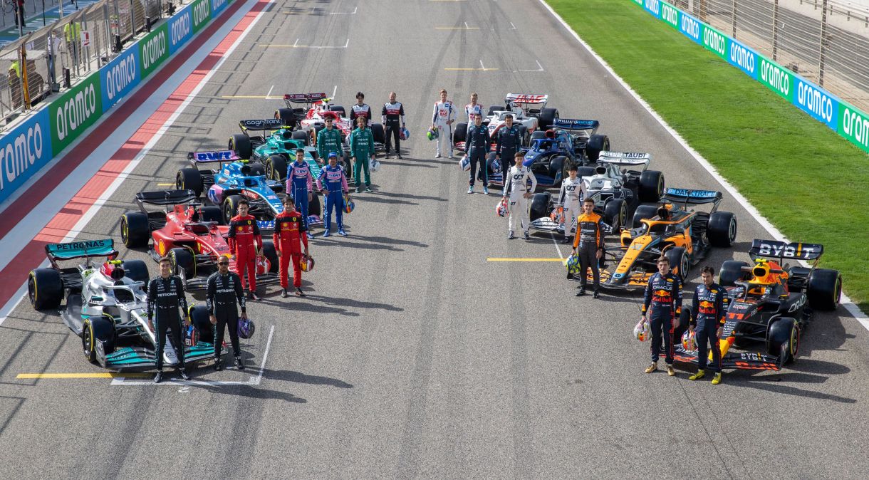 Pilotos das dez equipes da Fórmula 1 ao lado dos carros da temporada de 2022