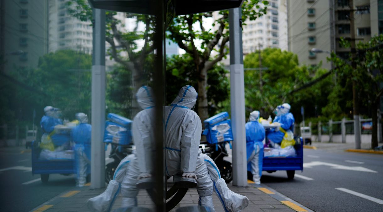 Trabalhador com traje de proteção fica de guarda em estação de ônibus durante bloqueio em meio à pandemia de Covid-19 em Xangai, China. 30 de abril de 2022