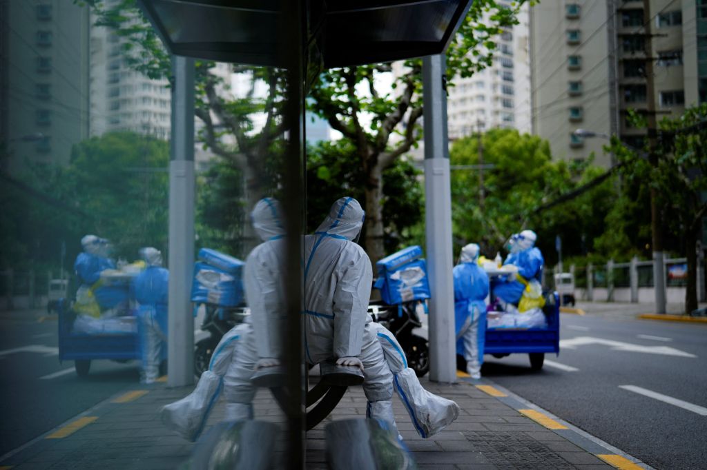 Trabalhador com traje de proteção fica de guarda em estação de ônibus durante bloqueio em meio à pandemia de Covid-19 em Xangai, China. 30 de abril de 2022