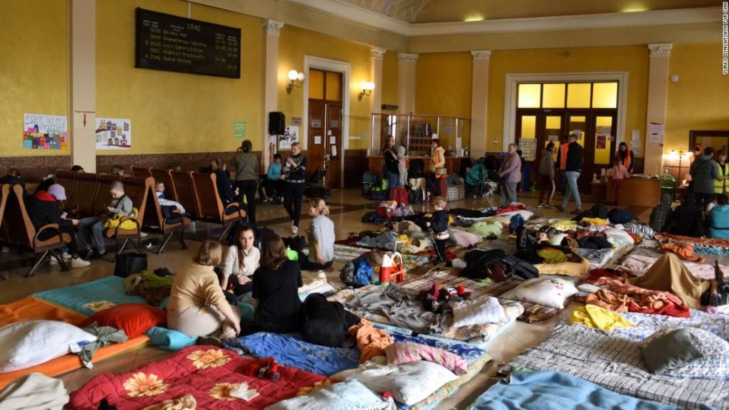 Mulheres e crianças em sala acima da estação de trem de Lviv, onde um canto foi convertido em área de recreação infantil, com brinquedos, livros e jogos