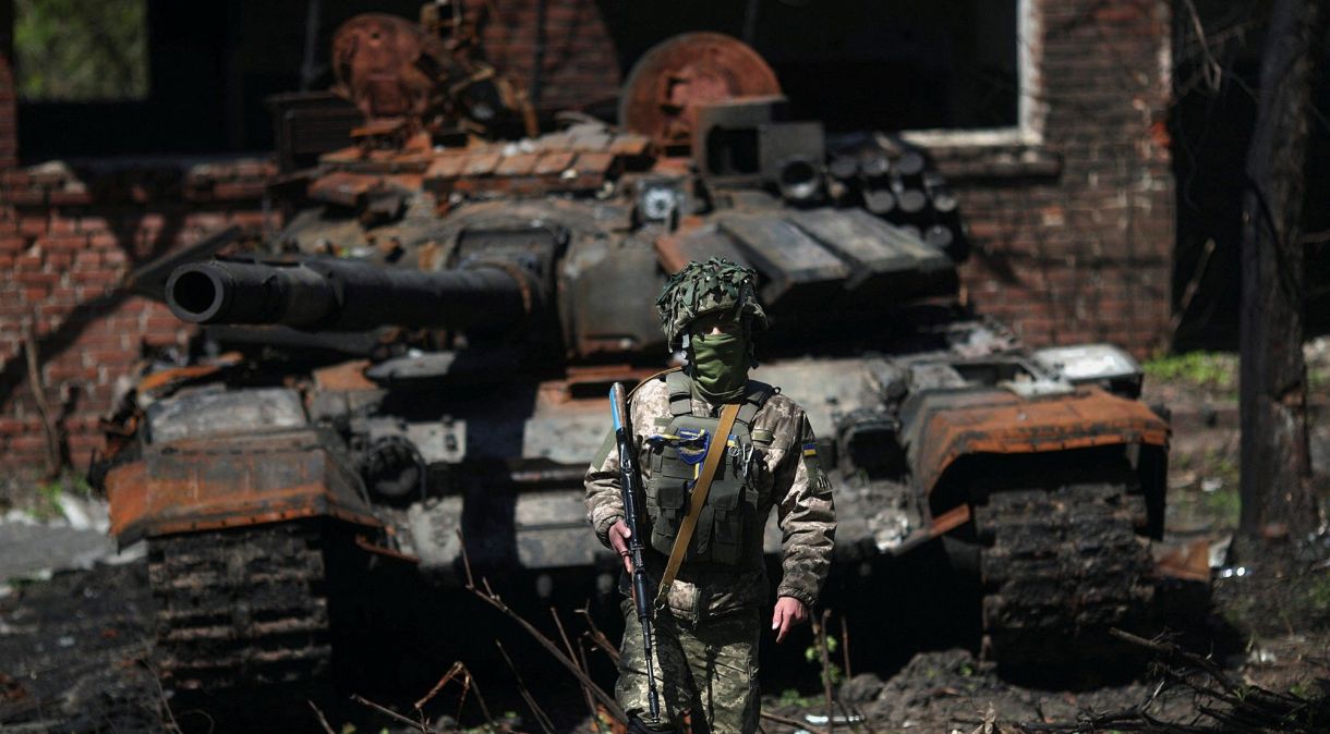 Soldado ucraniano em frente a tanque russo destruído em Kharkiv