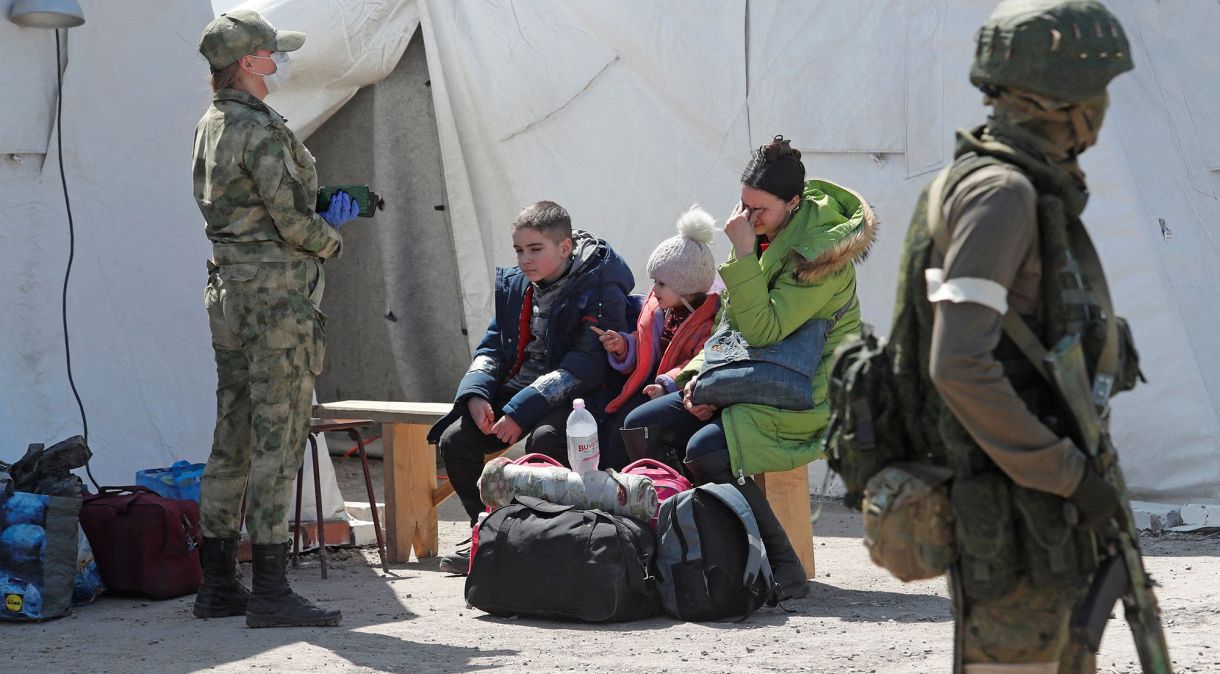 Mulher e filhos evacuados de Mariupol chegam à cidade de Benzemme, na região de Donetsk
