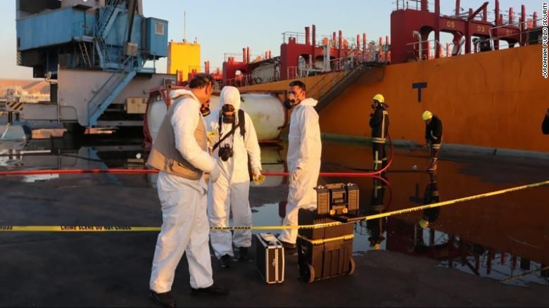 Trabalhadores em trajes de proteção respondem ao vazamento de gás tóxico no porto de Aqaba, na Jordânia, na segunda-feira (27)
