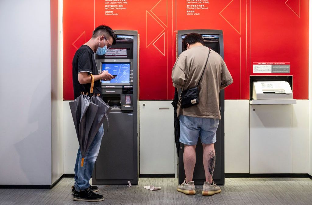 Clientes retiram dinheiro de um caixa eletrônico em Hong Kong