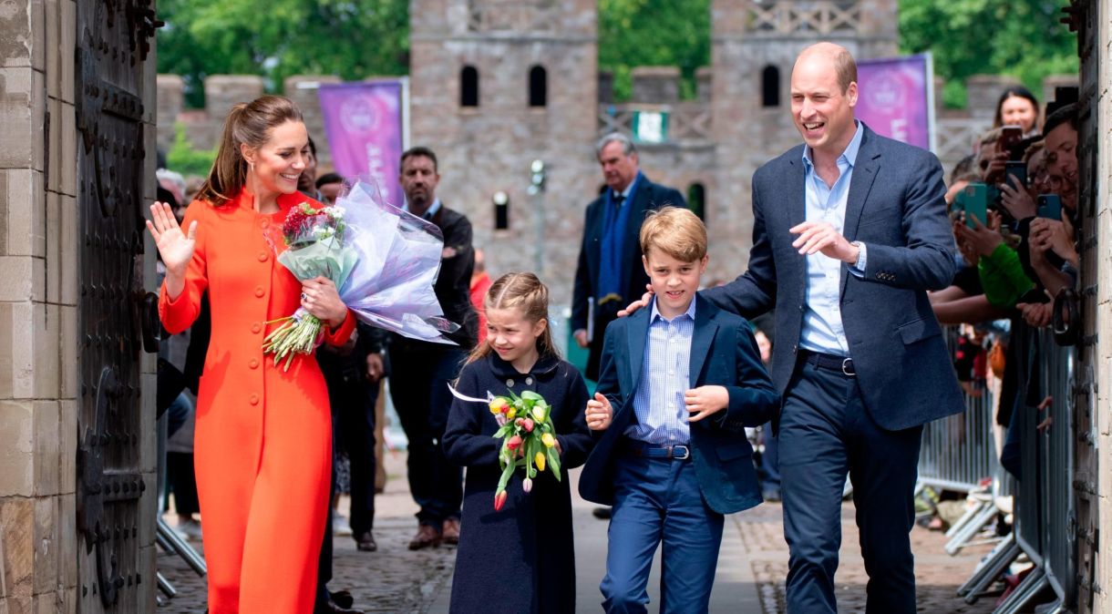 Em uma visita ao Castelo de Cardiff, o príncipe George combinou com seu pai, o príncipe William, um terno azul-marinho elegante, enquanto sua irmã, a princesa Charlotte, usava um casaco azul-marinho. Kate se destacou entre as paletas mais escuras em um casaco vermelho alaranjado
