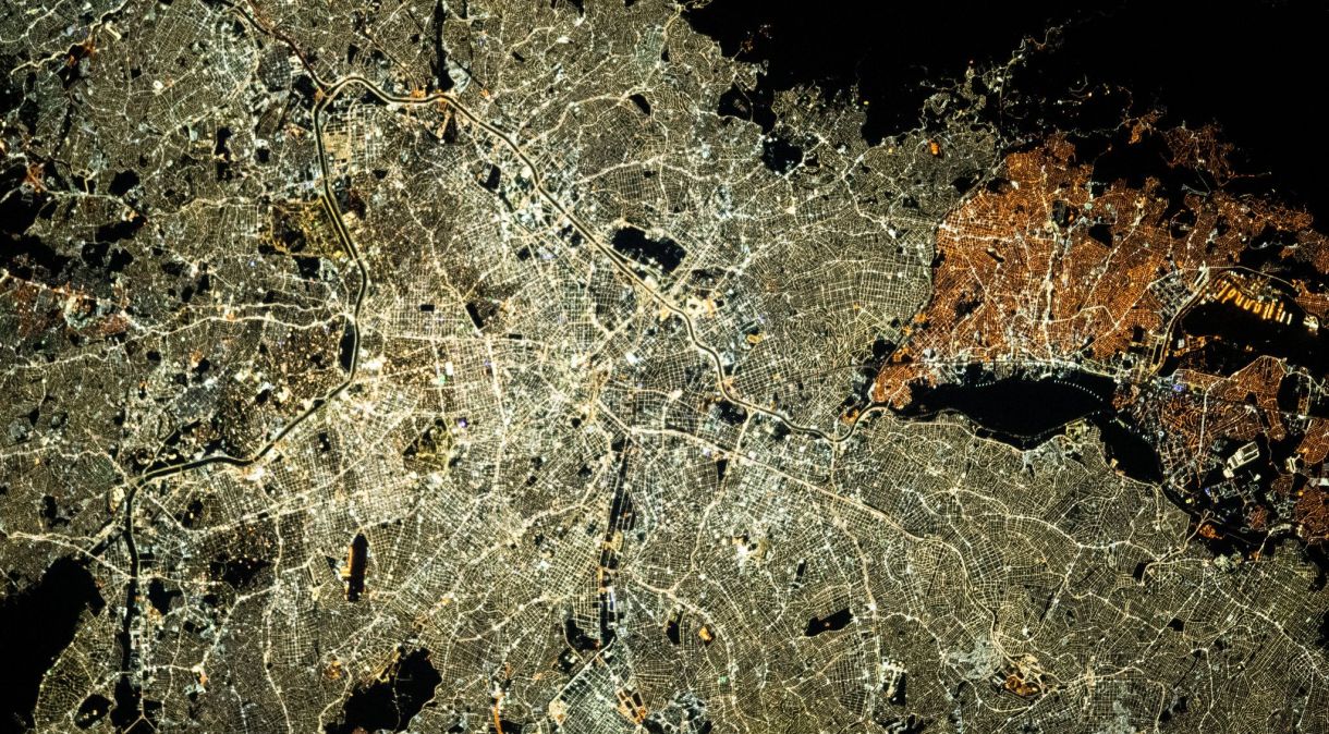 São Paulo, a cidade mais populosa do Brasil, pode ser diferenciada por suas luzes brilhantes em comparação com as luzes de rua mais amareladas de Guarulhos (à direita)