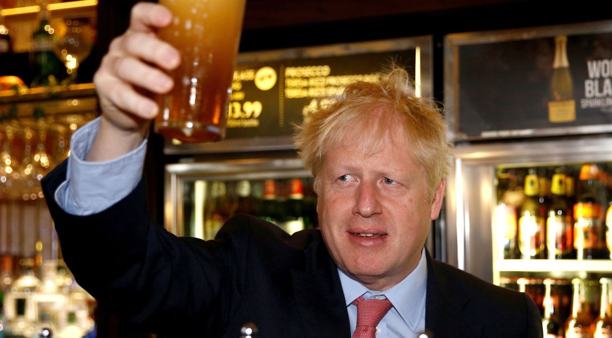Boris Johnson segura cerveja durante encontro com apoiadores em julho de 2019, em Londres.