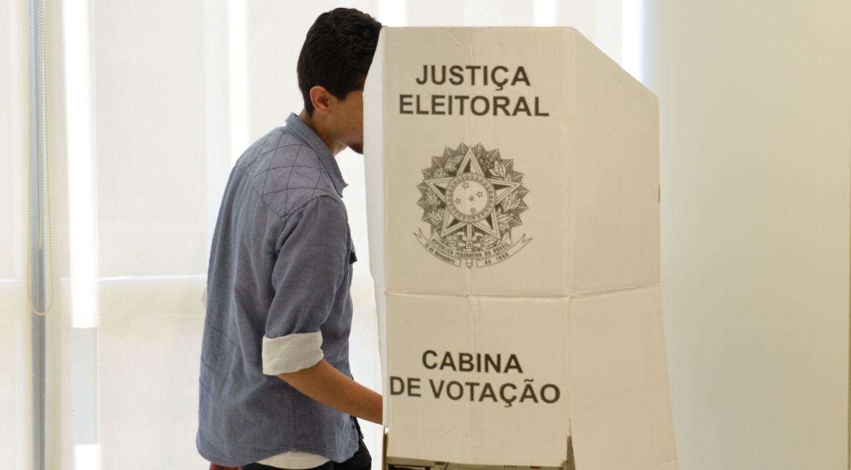 Eleitor entra em cabine de votação para eleições.
