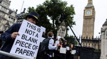 Para evitar prisões, manifestantes erguem cartazes em branco ou com mensagens simbólicas; Leis britânicas rígidas trazem à tona o debate sobre liberdade de expressão