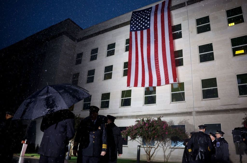 Membros das forças armadas e socorristas conversam entre si após o desdobramento de uma bandeira americana ao lado do Pentágono para comemorar o 21º aniversário dos ataques terroristas de 11 de setembro de 2022 em Arlington, Virgínia