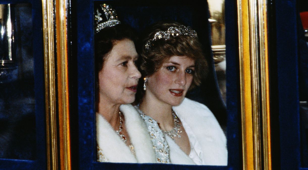A princesa de Gales e a rainha participam da Abertura do Parlamento em Londres, em novembro de 1982. Diana está vestindo um casaco de pele branco e a tiara Spencer
