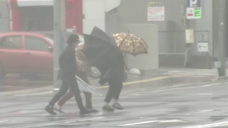 Pessoas nas ruas do Japão durante forte tempestade