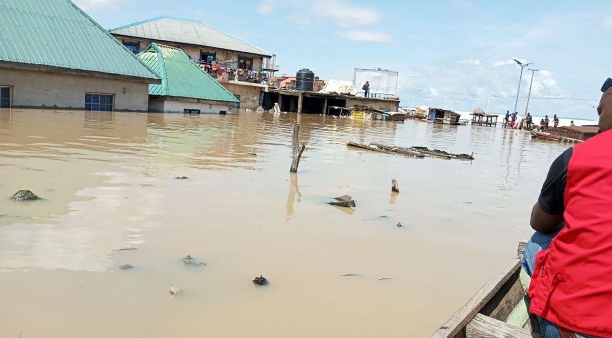 Um funcionário da Sociedade da Cruz Vermelha da Nigéria passa de canoa em um mercado submerso em Lokoja, capital do estado de Kogi, no centro-norte, em 27 de setembro de 2022