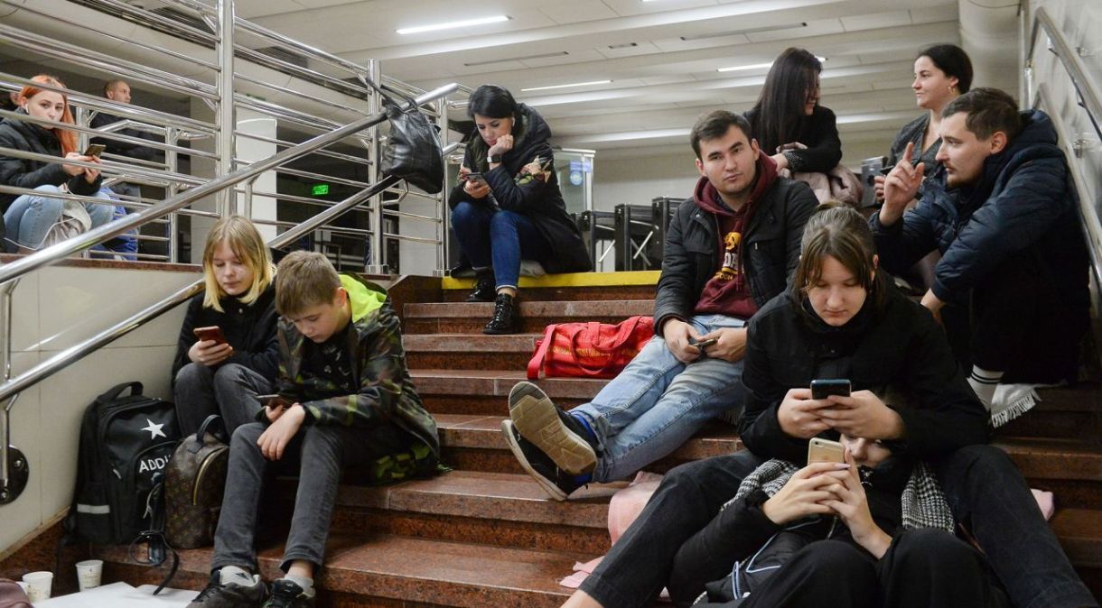 Pessoas checam seus telefones enquanto se abrigam dentro de uma estação de metrô durante um bombardeio em Kiev, na Ucrânia, em 31 de outubro.