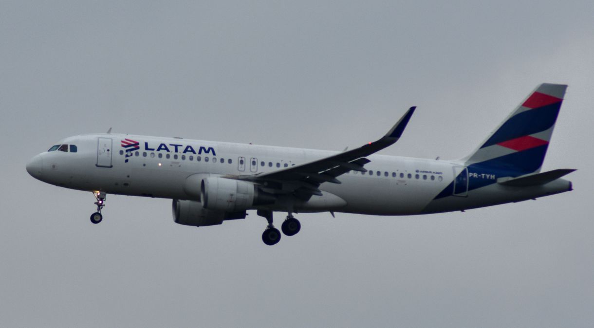 Avião da companhia aérea Latam voando próximo ao Aeroporto Internacional de Guarulhos