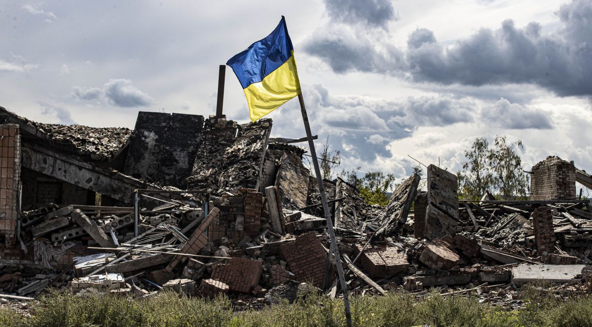 Bandeira ucraniana acenada em meio à destruição provocada pela guerra.