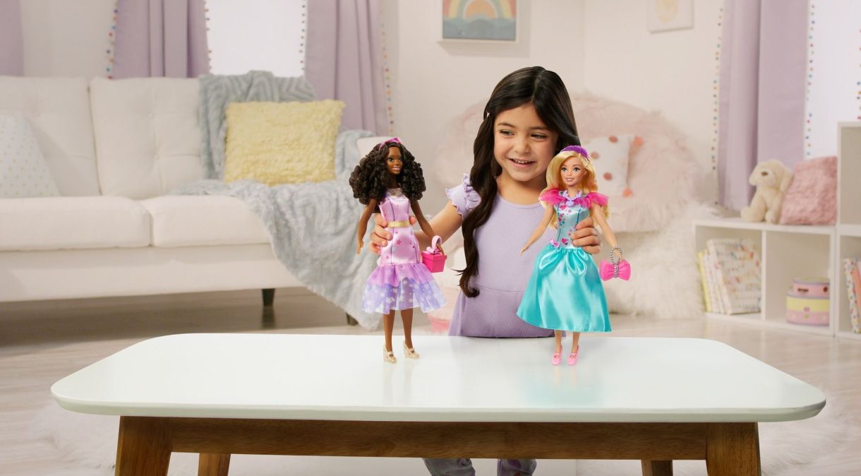 Criança brincando com bonecas da linha "Minha Primeira Barbie"