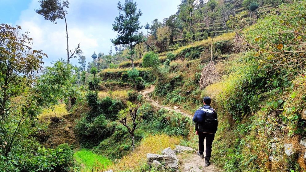 Homem caminhando na paisagem rural, vale do Nepal.