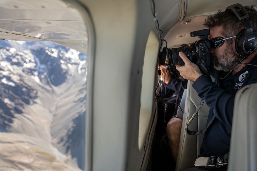 Levantamento da linha de neve no final do verão: cientista Andrew Lorrey tirando fotos durante o voo