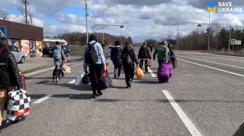 Trinta e uma crianças – puxando malas e sacolas com pertences, algumas segurando bichinhos de pelúcia – acompanhadas por familiares, foram abraçadas por voluntários após cruzarem a pé a fronteira