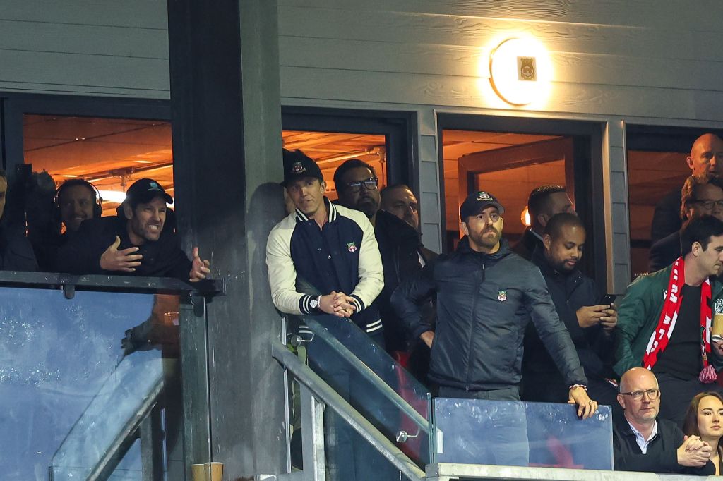 Paul Rudd, Rob McElhenney e Ryan Reynolds sofrem na arquibancada do Racecourse Ground