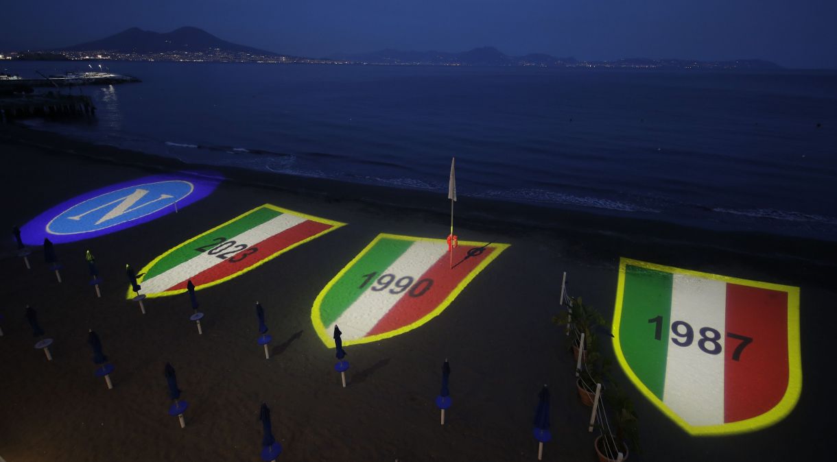 Iluminação especial projeta o possível Scudetto do Napoli em praia da cidade italiana.