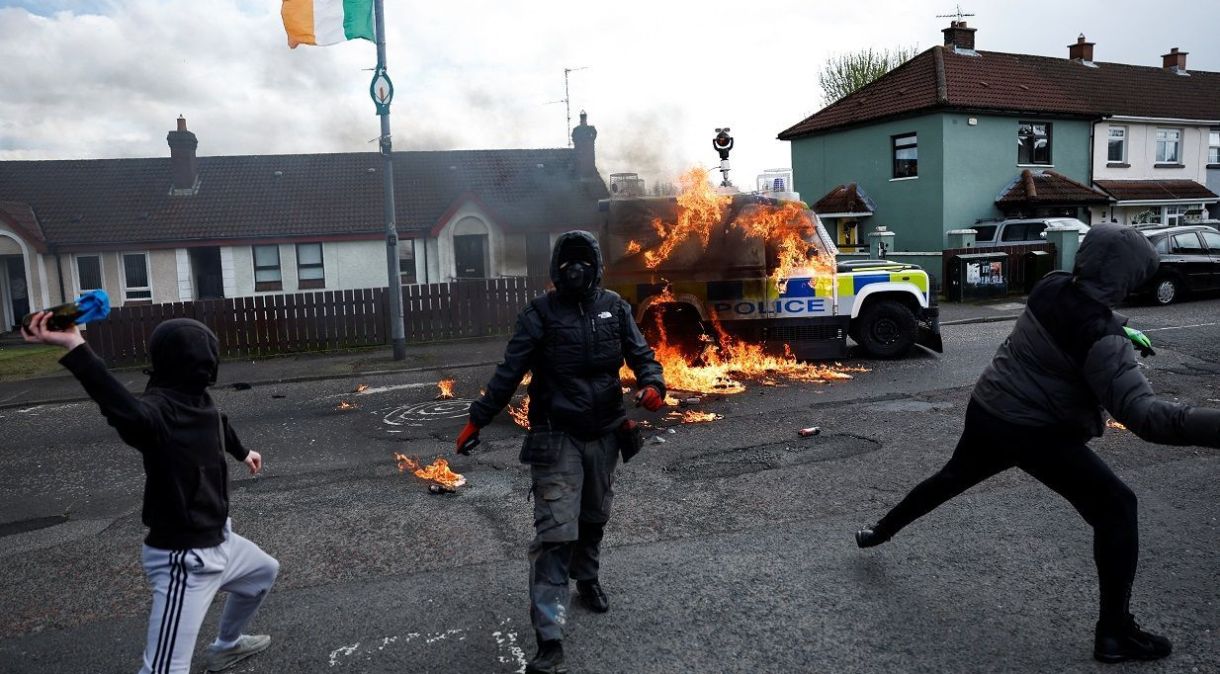 Membros do grupo nacionalista 'Republicanos dissidentes' atiram coquetéis molotov contra carro da polícia enquanto nacionalistas realizam manifestação contra acordo de paz em seu 25º aniversário, em Londonderry, Irlanda do Norte