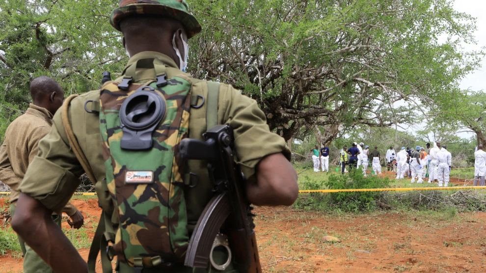 Policiais do Quênia montam guarda enquanto especialistas forenses e detetives de homicídios exumam corpos de supostos membros da seita