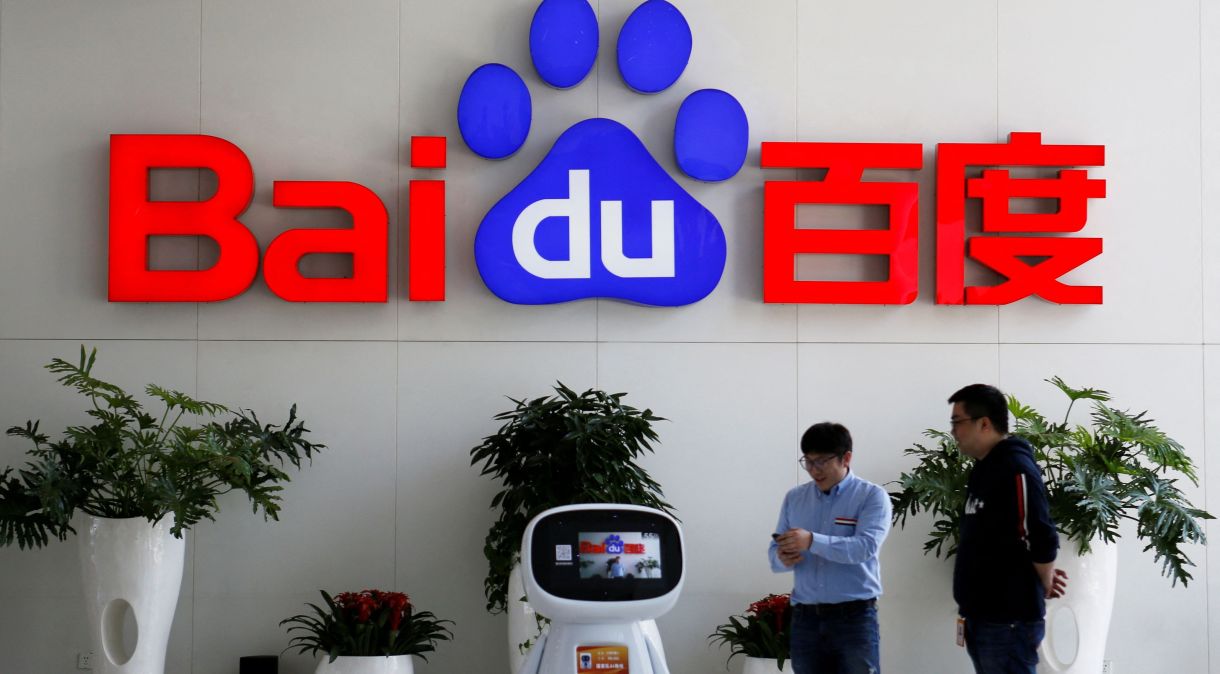 Homens interagem com robô de inteligência artificial da Baidu na sede da empresa, em Pequim.