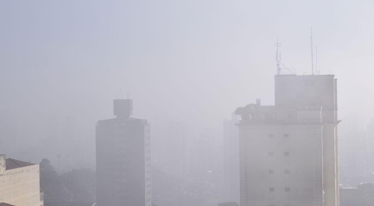 Na foto, prédios residenciais encobertos por neblina