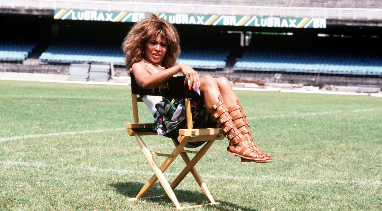 Tina Turner em uma cadeira no meio do campo do Maracanã