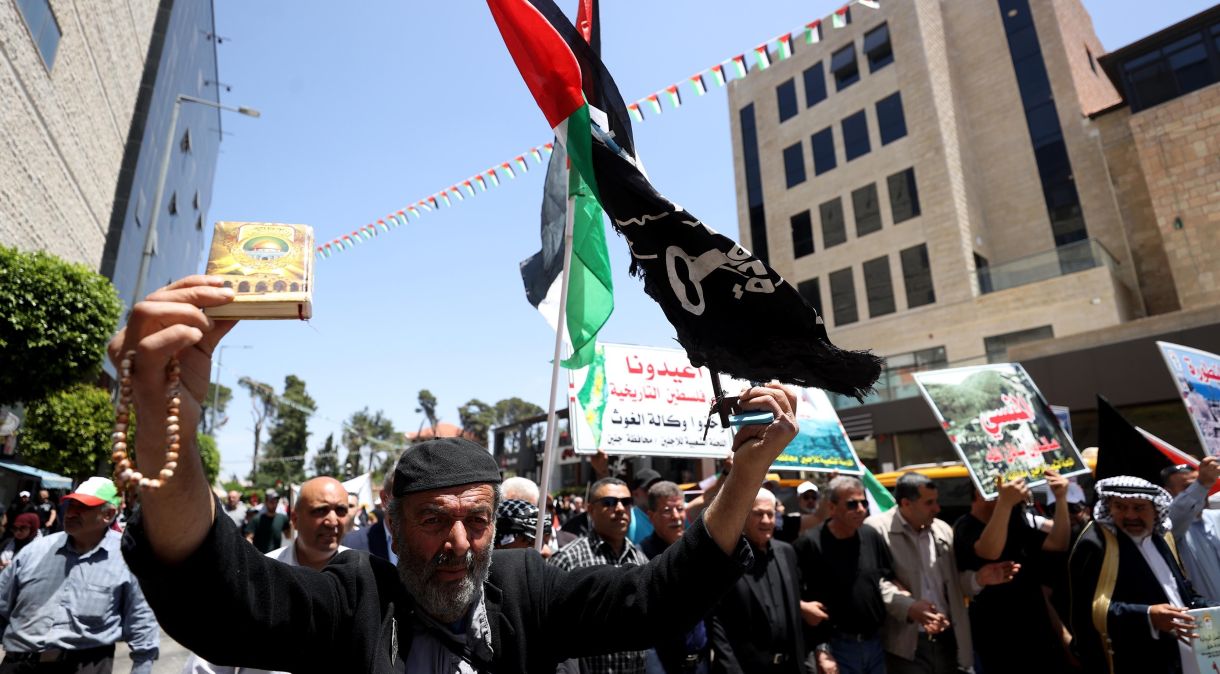 Palestinos marcham com faixas no 75º aniversário da declaração de independência de Israel, que os palestinos chamam de Grande Catástrofe (Nakba)