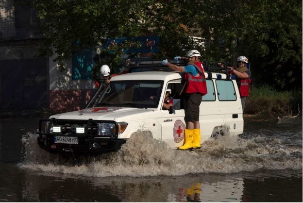 Trabalhadores da Cruz Vermelha dirigem pela Kherson alagada em 6 de julho.