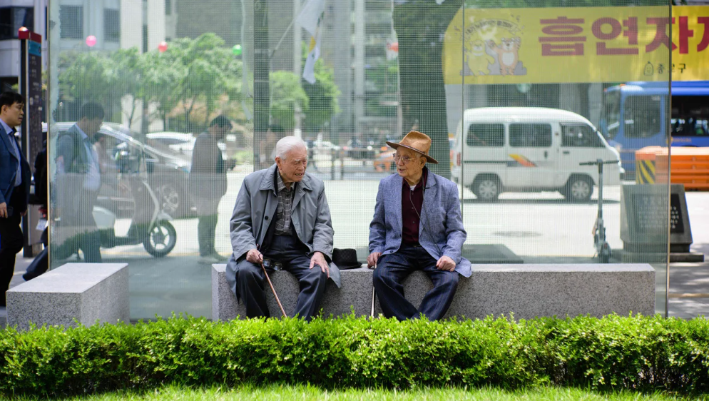 Dois idosos conversam em um banco em Seul, Coreia do Sul, em 11 de maio de 2023.
