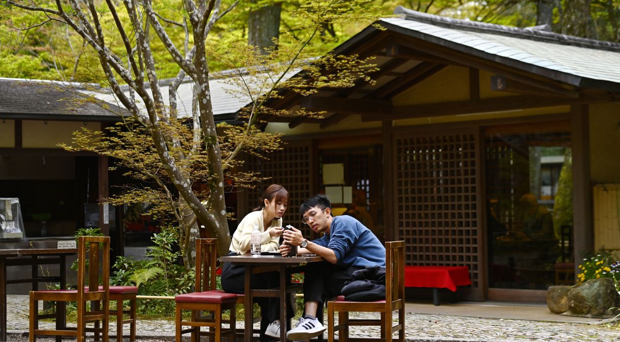 Um jovem casal de turistas relaxa em uma tradicional casa de chá japonesa no Parque Nara.